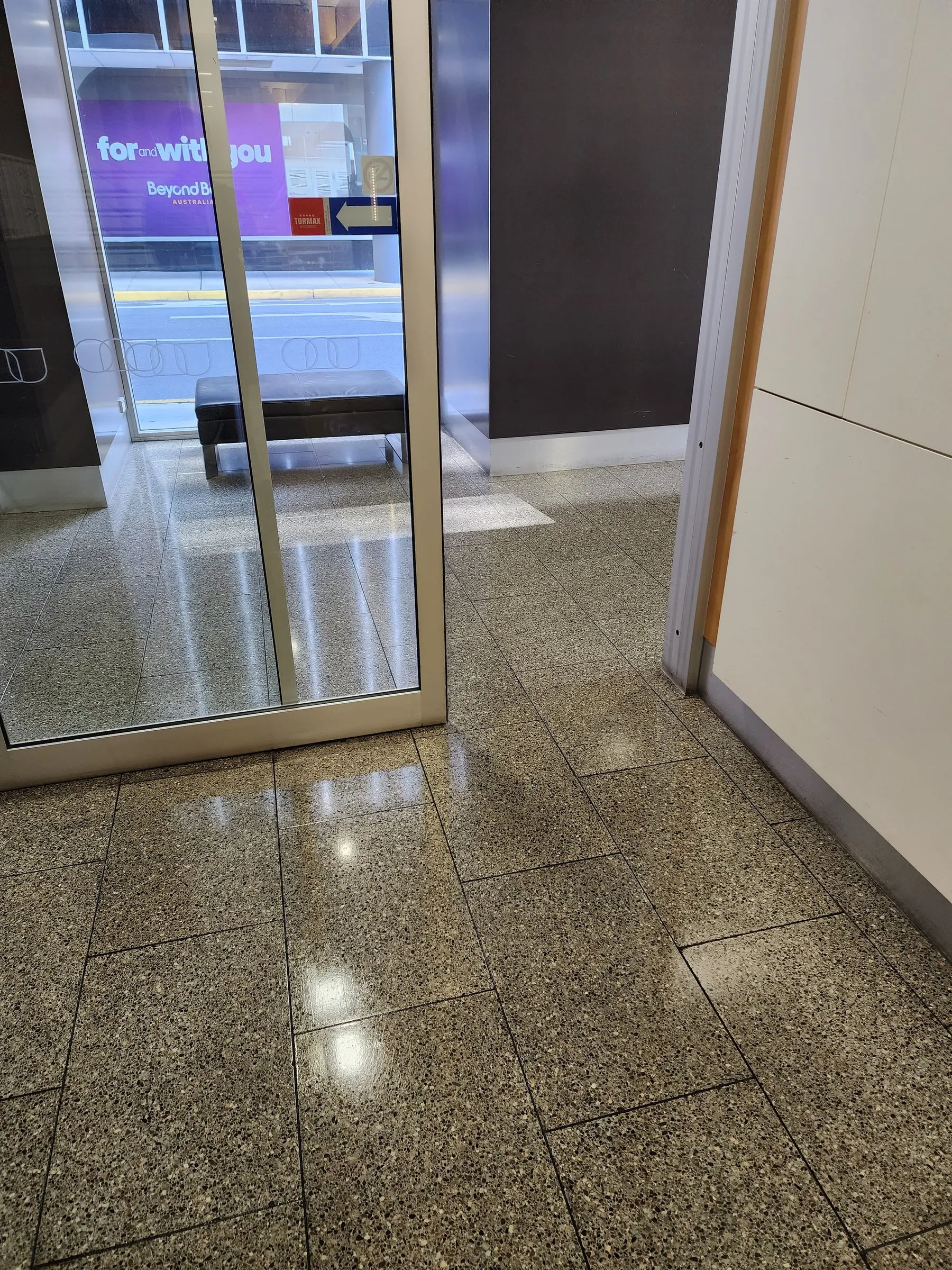 Glass shopfront entry over a clean terrazzo floor