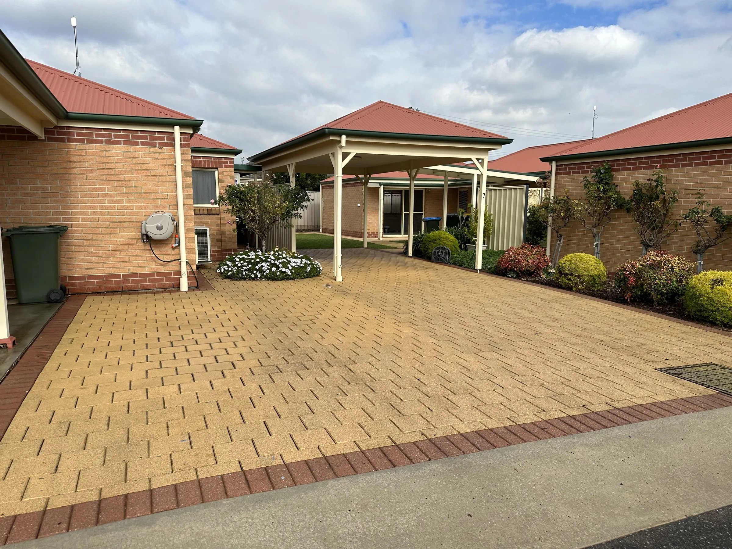 Strata courtyard with brick pavers, pergola and bins after a pressure clean